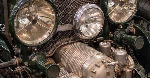 An antique car with headlights and a grill