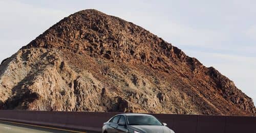 A car driving on a road near a mountain