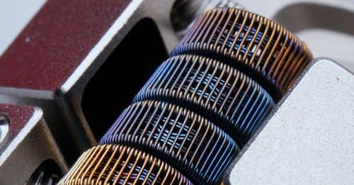 Closeup of fused clapton coil on dripper of modern electronic cigarette on white background