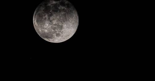 Full moon shining on black background