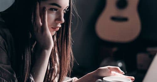 Photo of Woman Lying on Bed While Using Laptop