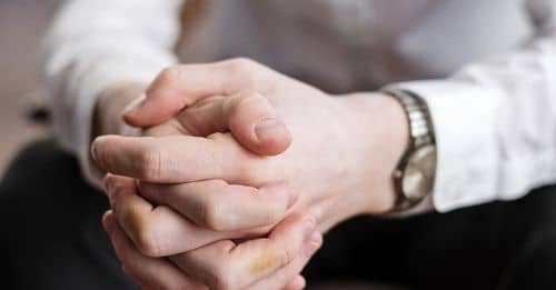 Man in White Dress Shirt Holding Hands of Woman in Black Dress Pants