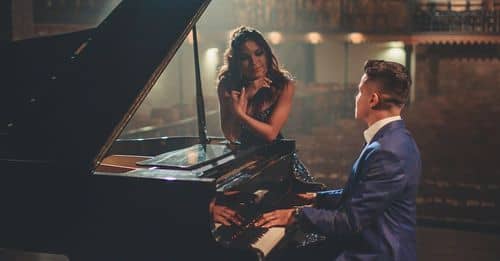 Man playing piano for woman