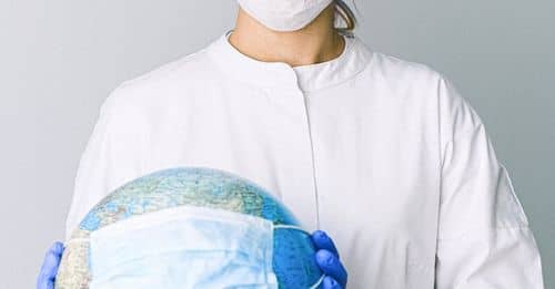 Photo Of Person Wearing Protective Wear While Holding Globe