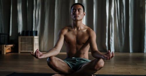 Topless Man in Blue Denim Shorts Sitting on Floor