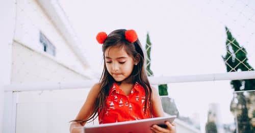 Smart child browsing tablet on street