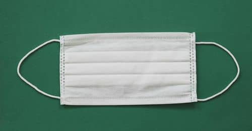 Photo of White Face Mask Against Green Background