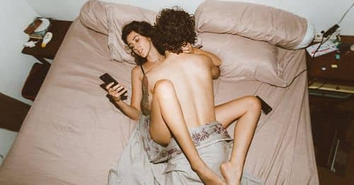 Couple having sex and using smartphone