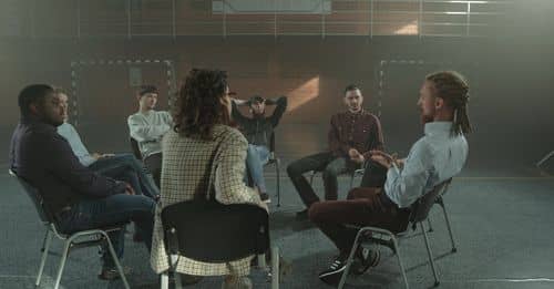 People Sitting on Chairs Inside a Gymnasium