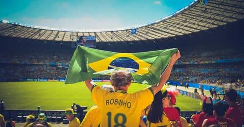 Man Raising Brazil Flag Inside Football Stadium