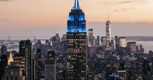 High rise buildings illuminated by lights in evening time