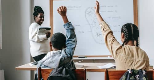 Black woman with pupils in classroom