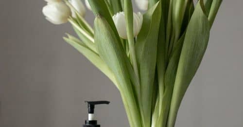 Bouquet of tulips placed near cosmetic products on table