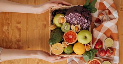 Person Holding A Basket Of Fruits