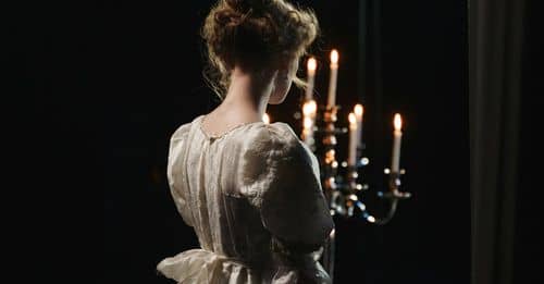 Girl in White Dress Holding A Candelabrum