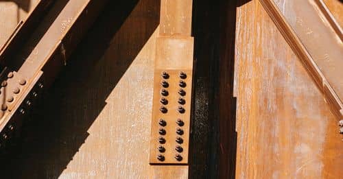 Part of metal rusty structure of factory building in sunlight in industrial zone