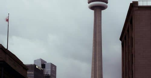 Tall CN tower in city with cars