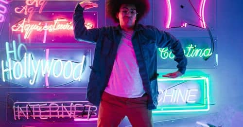 Man Dancing with Neon Lights and Signs on Background