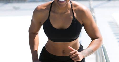 Woman Wearing Black Sports Bra and Jogger Shorts Smiling