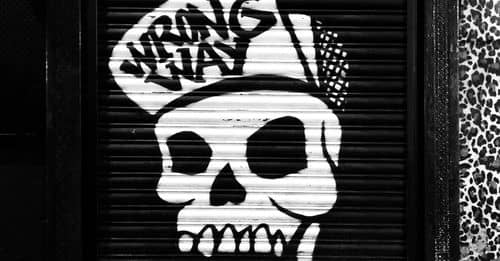 Funky skull graffiti on locked roll down black door