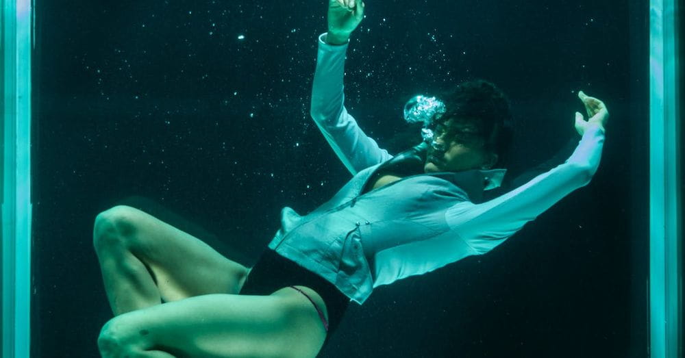 Person Wearing White Long-sleeved Shirt in Underwater