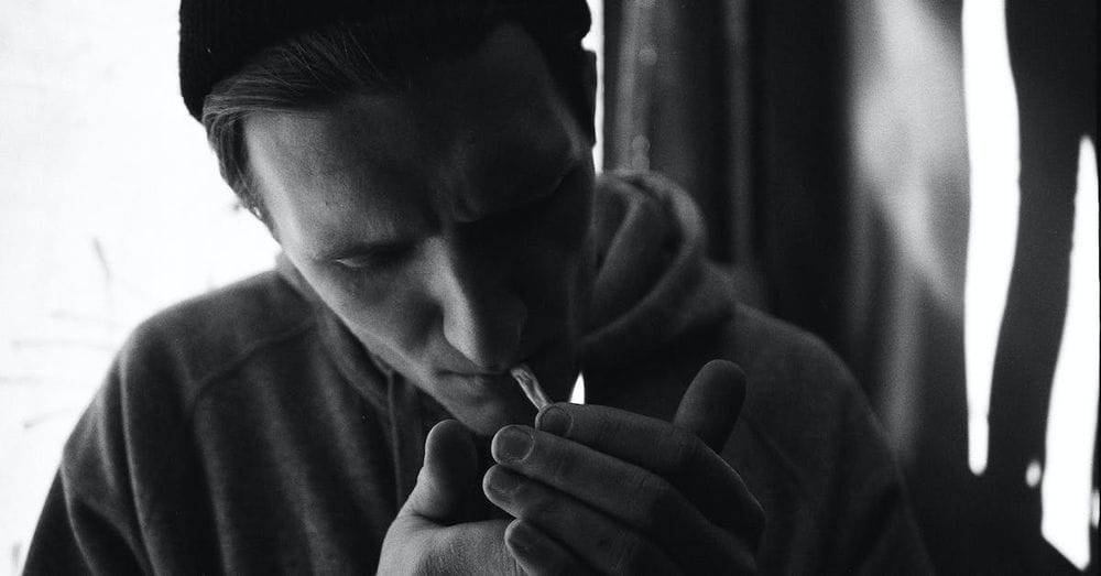 A man smoking a cigarette in black and white