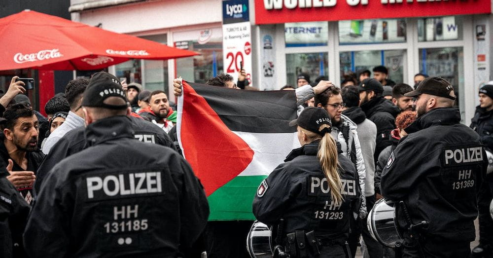 Police Standing in front of the Protestants with the Flag of Palestine