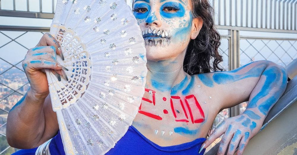 A woman with blue face paint and a fan