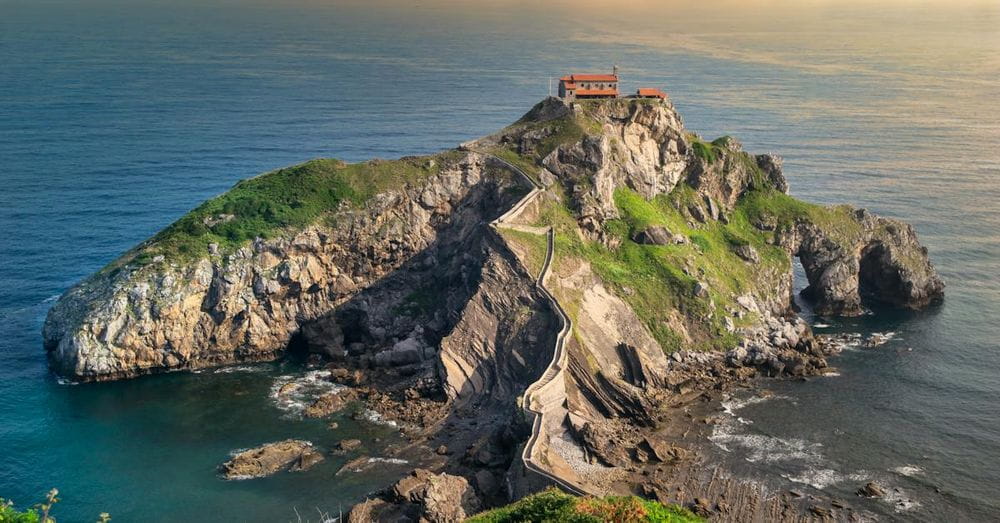 A small island with a lighthouse on top of it