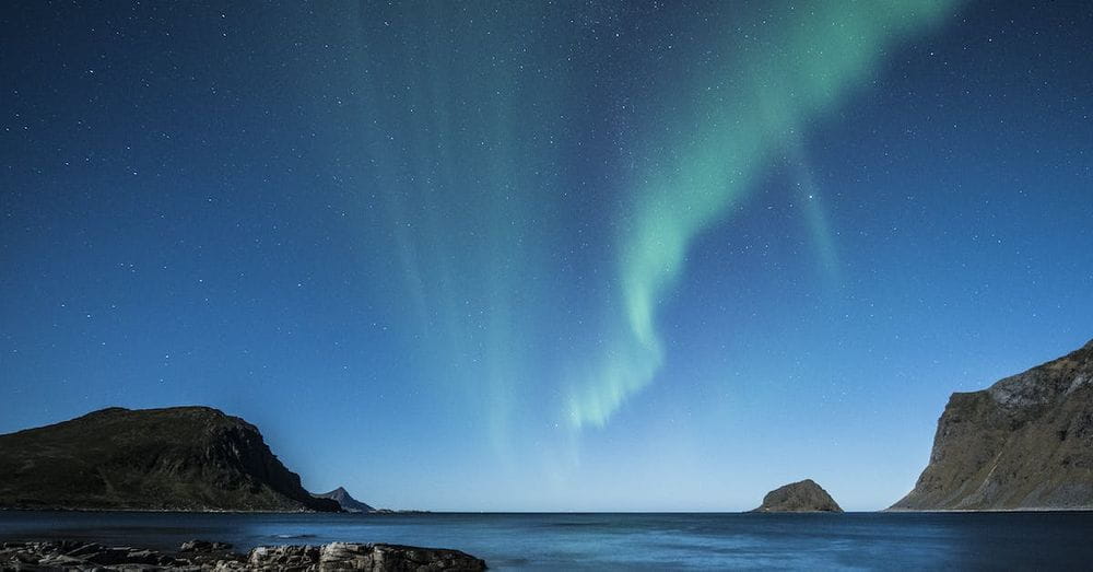 Green Aurora Lights Above Body of Water