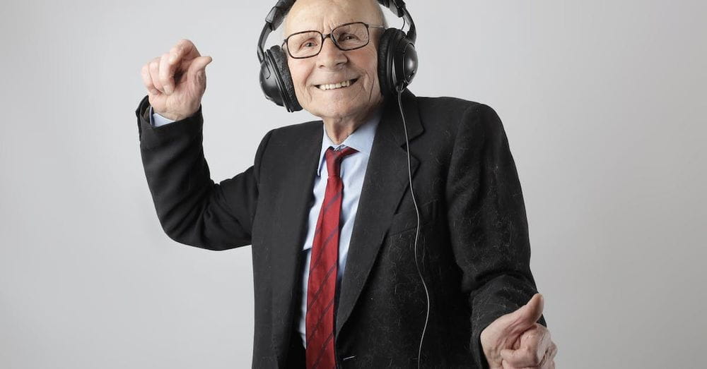 Cheerful elderly man listening to music in headphones