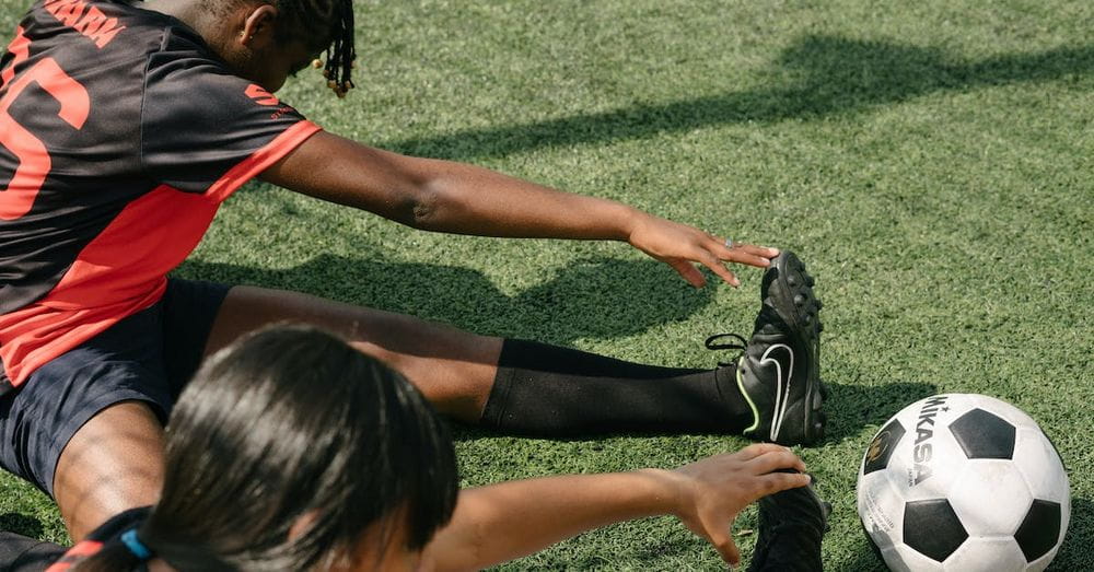 From above of young African American female soccer players warming up during practice