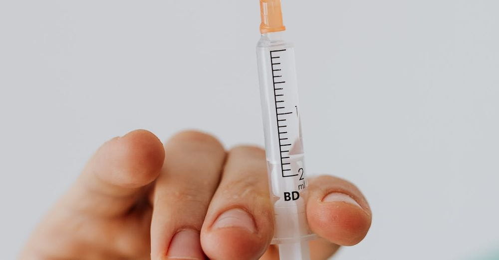 Close-up View Of Person Holding A Vaccine