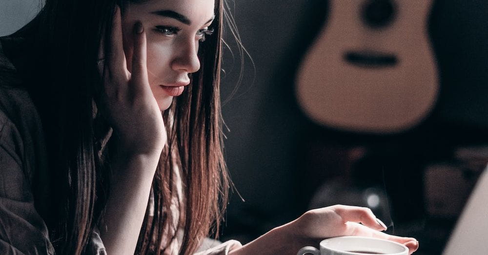 Photo of Woman Lying on Bed While Using Laptop