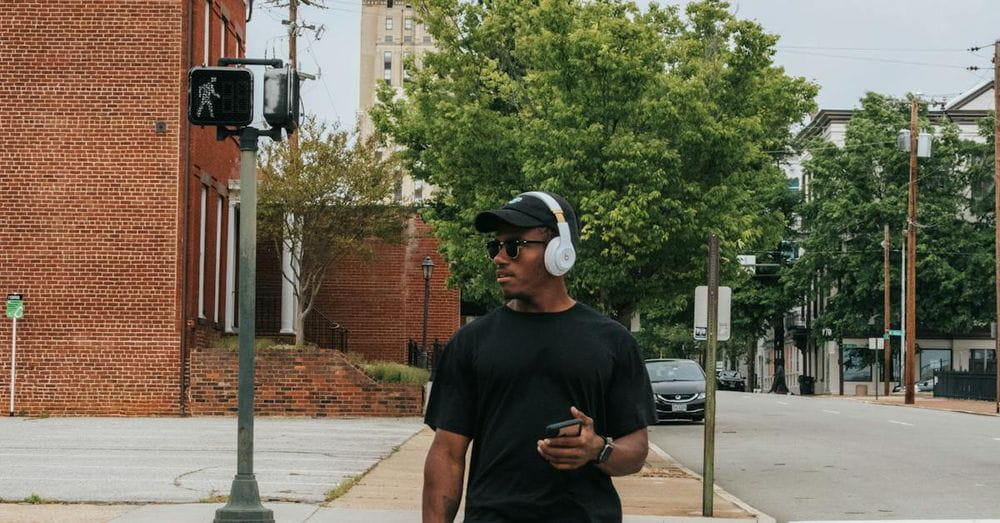 Man in Black Crew Neck T-shirt and Blue Denim Jeans Crossing on Pedestrian Lane