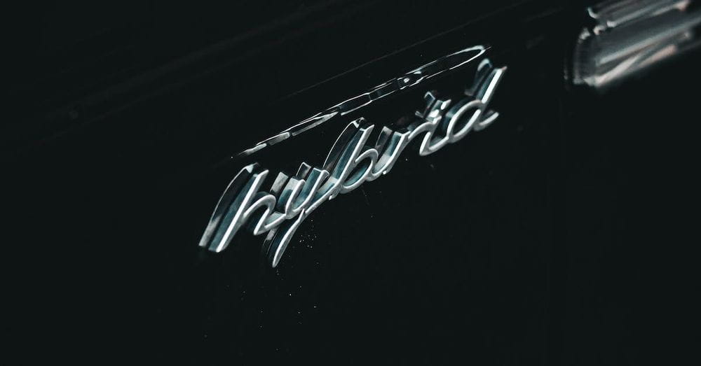 From above of contemporary black hybrid auto with creative title and water droplets on surface