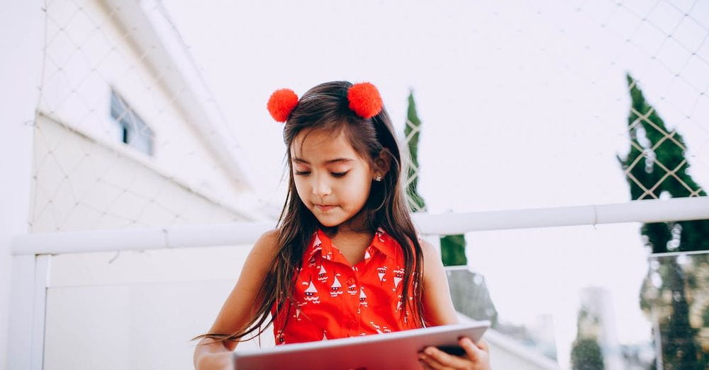 Smart child browsing tablet on street