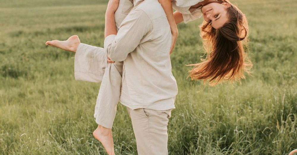 Man Carrying Woman In The Middle Of A Grass Field