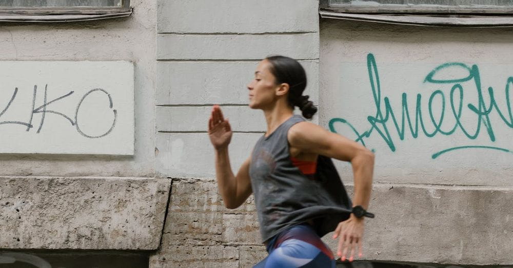 A Side View of a Woman Jogging on the Street