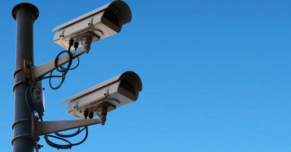 Surveillance cameras against blue sky