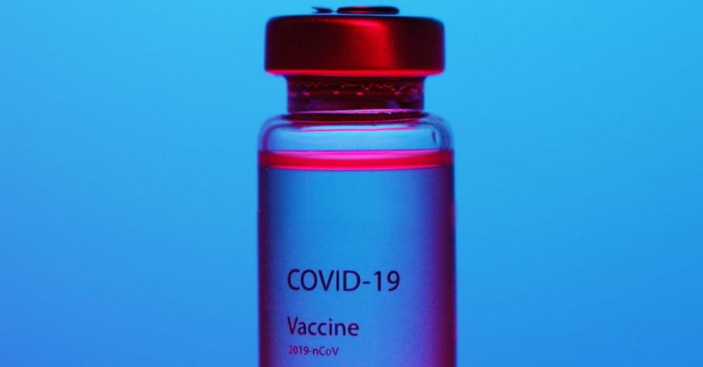 A Close-Up View of a Covid-19 Vaccine Vial on Blue Background