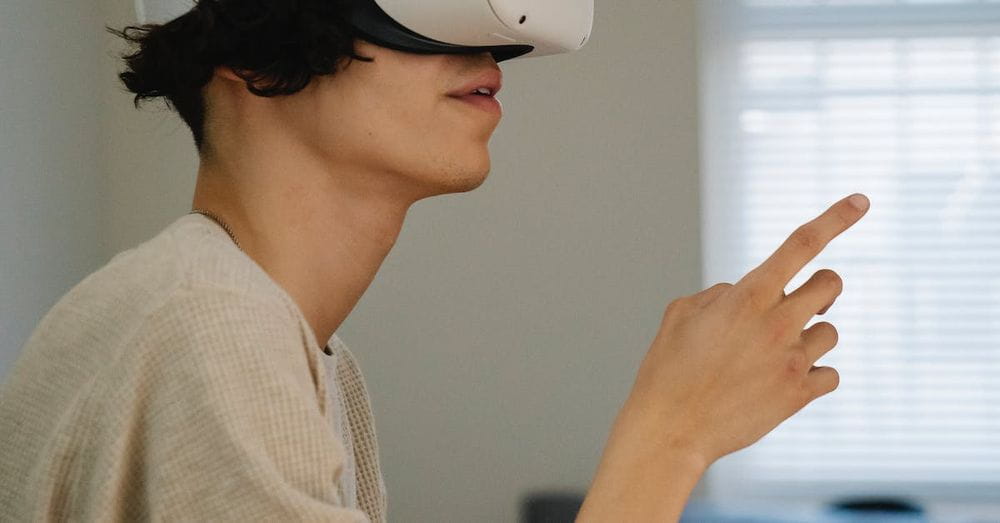 Side view of male gesticulating while experiencing virtual reality in headset in house room in daytime